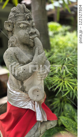 Garden Gnome traditional stone statue situated in a tranquil tropical garden, surrounded by vibrant foliage and artistic decor, harmonizing with the natural beauty of its environment Garden Gnome traditional stone statue situated in a tranquil tropical garden, surrounded by vibrant foliage and artistic decor, harmonizing with the natural beauty of its environment 122527804