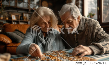 Senior couple working on a jigsaw puzzle together in their cozy living room. 122528214