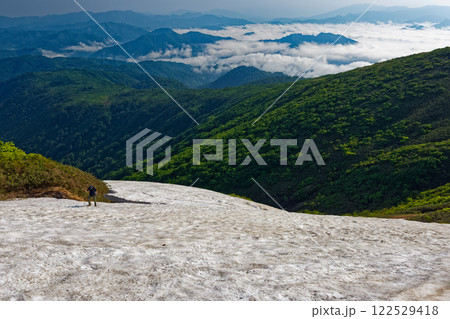 浅草岳稜線の雪渓を行く登山者と只見の雲海 浅草岳稜線の雪渓を行く登山者と只見の雲海 122529418