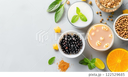 Assortment of ingredients for making bubble tea, including tapioca pearls, milk, fruit, and tea. 122529685