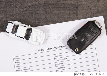 White toy car, car key and vehicle sales agreement. Sales or purchases new or used vehicle 122531664