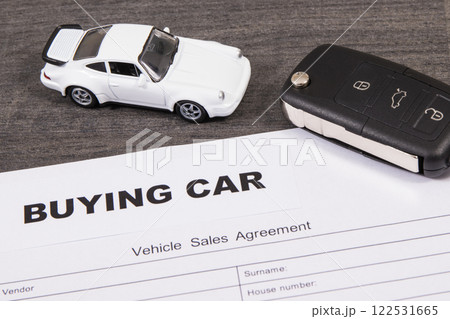 White toy car, car key and vehicle sales agreement 122531665