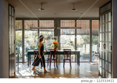 Woman Walking Through Bright Modern Interior Woman Walking Through Bright Modern Interior 122533411