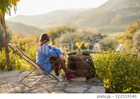 Woman Relaxing on Rustic Patio 122533540