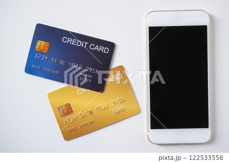Pile of credit cards with smartphone on white background. Cashless technology and credit card payment concept. Pile of credit cards with smartphone on white background. Cashless technology and credit card payment concept. 122533556