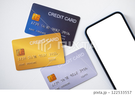 Pile of credit cards with smartphone on white background. Cashless technology and credit card payment concept. Pile of credit cards with smartphone on white background. Cashless technology and credit card payment concept. 122533557