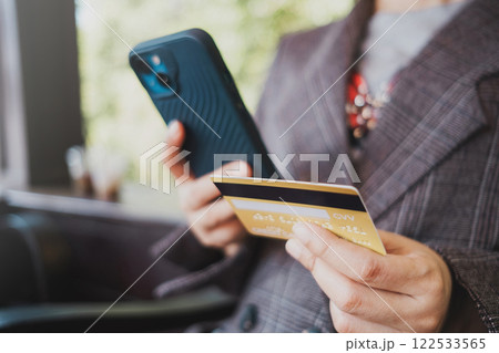 Close up female hands holding credit card and smartphone, shopping online, buying on internet. 122533565