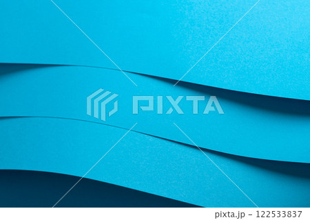 Blue paper background with a smooth matte finish and layered edges. Vibrant pastel tones and a 122533837