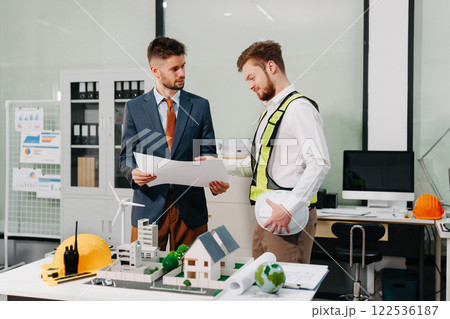 Engineering Team Collaborates on Blueprint Model in Corporate Office. Engineering Team Collaborates on Blueprint Model in Corporate Office. 122536187