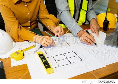Engineer teams meeting working together wear worker helmets hardhat on construction site in modern city 122536253