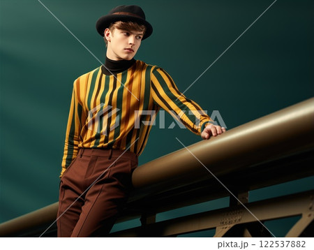 Confident man wearing vintage clothes and hat is posing on a bridge, showcasing a unique and stylish look with suspenders and colorful attire 122537882
