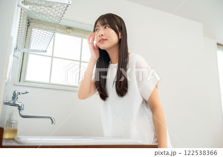 洗面台の鏡で肌を確認する日本人女性 洗面台の鏡で肌を確認する日本人女性 122538366