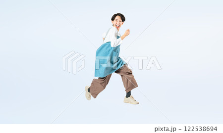 ジャンプするエプロンをつけたミドル女性の全身写真 ジャンプするエプロンをつけたミドル女性の全身写真 122538694