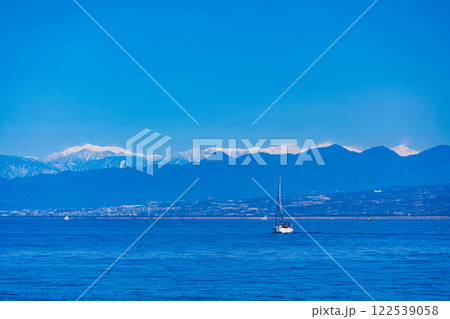 【静岡県】駿河湾に浮かぶ小船と冠雪した南アルプス 122539058