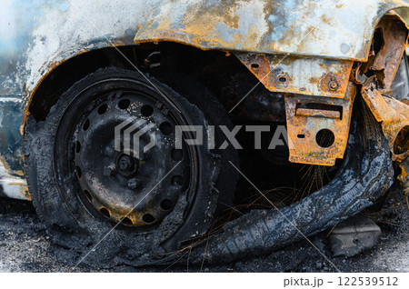 Close-up of burnt wheel. Black charred tire with wire cord. 122539512