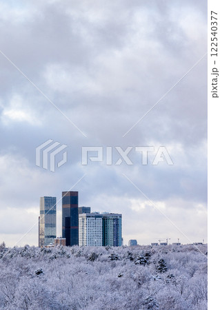 cloudy sky over skyscrapers and park after snowing cloudy sky over skyscrapers and park after snowing 122540377