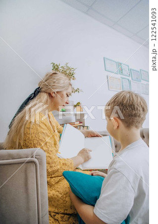 woman engaging in reading activity with child in cozy indoor setting concept of early childhood education, literacy, and family learning woman engaging in reading activity with child in cozy indoor setting concept of early childhood education, literacy, and family learning 122541093