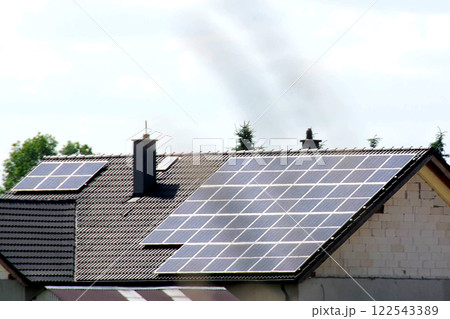 Installing a Solar Cell on a Roof. Solar panels on roof. Historic farm house with modern solar panels on roof and wall. High quality photo Installing a Solar Cell on a Roof. Solar panels on roof. Historic farm house with modern solar panels on roof and wall. High quality photo 122543389