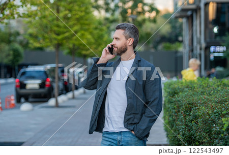 man having mobile call in the street. man call on mobile outside. photo of man call 122543497