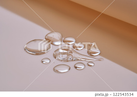 Few drops of serum on a beige background. 122543534