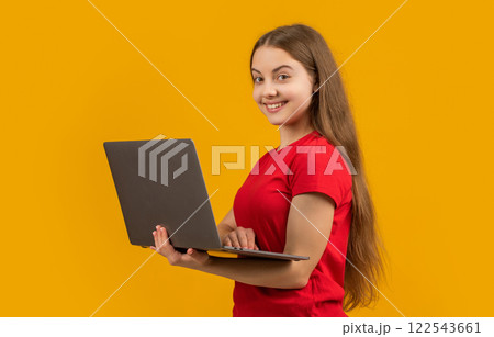 happy child with laptop on yellow background happy child with laptop on yellow background 122543661