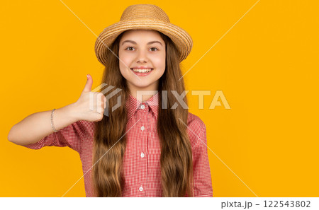 happy teen kid in straw hat on yellow background. thumb up 122543802