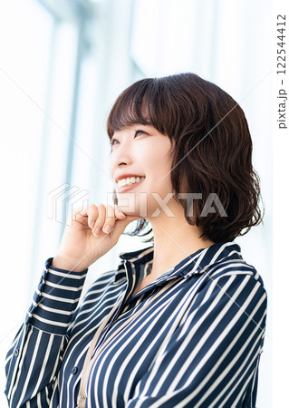 窓の外を見る笑顔の女性・ビジネスウーマン 窓の外を見る笑顔の女性・ビジネスウーマン 122544412