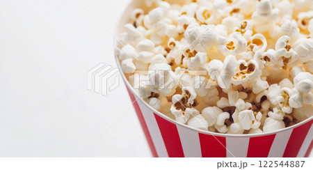 Popcorn bucket. Red and white stripes. Movie night snack. Minimalist food photography style white background. 122544887