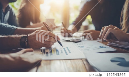 Team meeting with charts and documents on table. Team meeting with charts and documents on table. 122545865