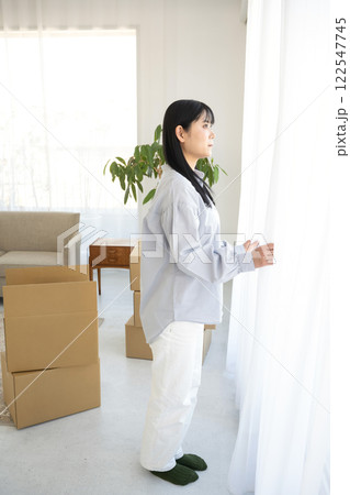 部屋の窓から外の風景を見る女性 部屋の窓から外の風景を見る女性 122547745