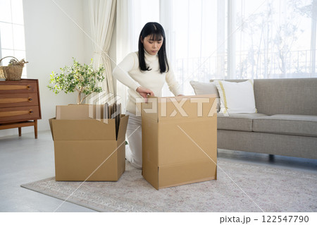 段ボールを壊して片づける女性 122547790