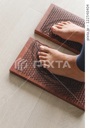 Yoga woman legs standing on nails with singing meditation bowl top view closeup Yoga woman legs standing on nails with singing meditation bowl top view closeup 122548404