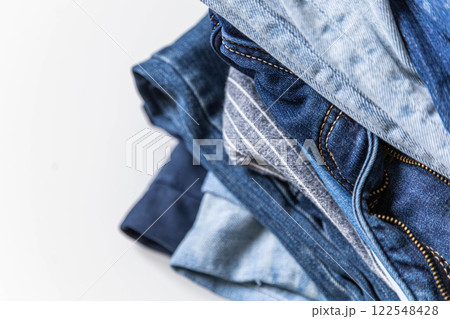 Stack of various shades of blue jeans on white background 122548428