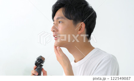 シェーバーで髭を剃る男性 122549087