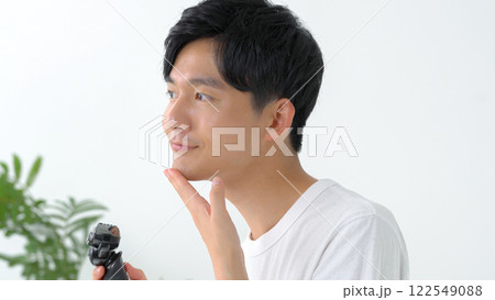 シェーバーで髭を剃る男性 122549088