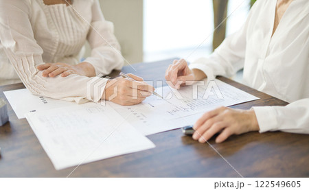 不動産の契約を結ぶ女性2人の手元 不動産の契約を結ぶ女性2人の手元 122549605