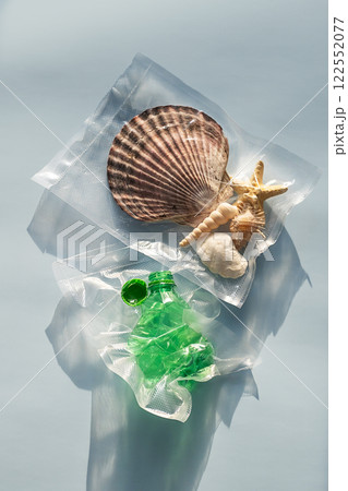 Sea shells and plastic bottle vacuum-sealed pack. Nature vs plastic waste concept. Sea shells and plastic bottle vacuum-sealed pack. Nature vs plastic waste concept. 122552077