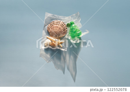 Sea shells and plastic bottle vacuum-sealed pack. Nature vs plastic waste concept. 122552078