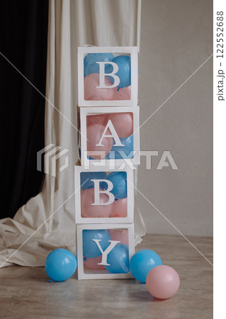 Decorations for a gender party in the form of transparent boxes with pink and blue balloons. 122552688