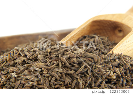 Wooden scoop picking caraway seeds from brown bowl Wooden scoop picking caraway seeds from brown bowl 122553005