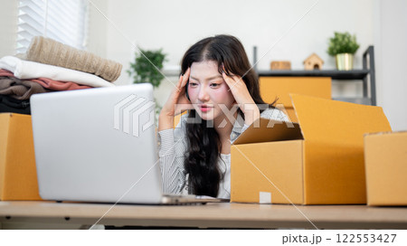 A tired, stressed Asian female online shop owner is concerned about the lack of online orders. 122553427