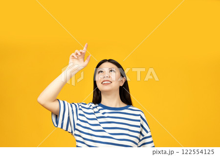 A girl of Asian appearance, on a yellow background. A girl of Asian appearance, on a yellow background. 122554125