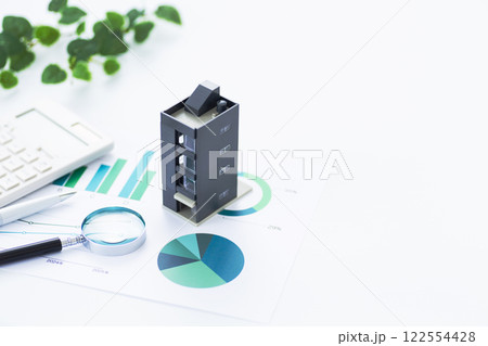 ビジネスグラフと企業ビルと電卓とルーペ ビジネスグラフと企業ビルと電卓とルーペ 122554428
