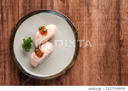 Seared Salmon Sushi with Sauce and Green Onion Topping Served on a Plate Seared Salmon Sushi with Sauce and Green Onion Topping Served on a Plate 122554604