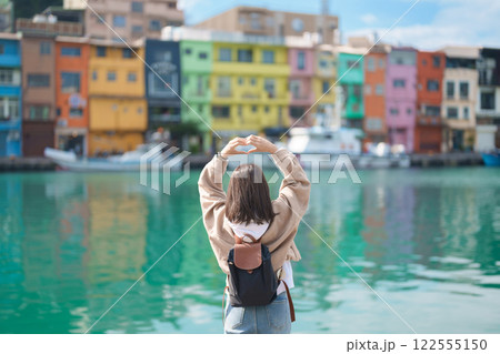 woman traveler visiting in Taiwan, female Tourist with backpack sightseeing at Keelung, Colorful Zhengbin Fishing Port. Popular landmarks and attractions near Taipei City.  Asia Travel concept 122555150
