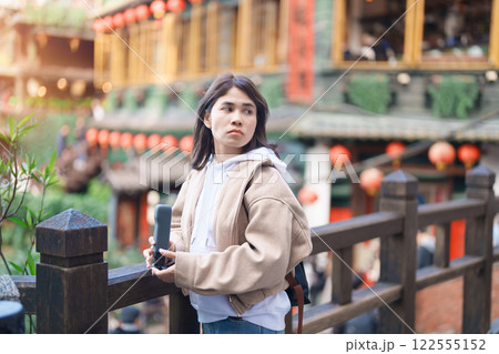 woman traveler visiting in Taiwan, female Tourist with backpack sightseeing at Jiufen Old Street village with Tea House background. Popular landmarks and attractions near Taipei City. Travel concept 122555152