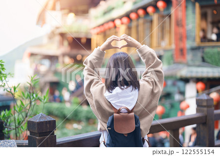 woman traveler visiting in Taiwan, female Tourist with backpack sightseeing at Jiufen Old Street village with Tea House background. Popular landmarks and attractions near Taipei City. Travel concept 122555154