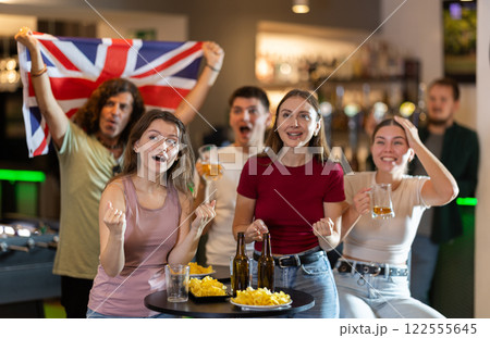 Emotional United Kingdom fans with national flag watch the match on TV with interest and actively comment Emotional United Kingdom fans with national flag watch the match on TV with interest and actively comment 122555645