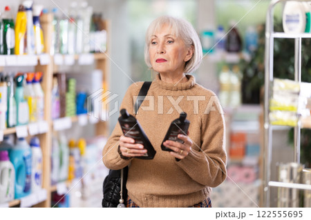 Mature woman choosing hair care products in department store Mature woman choosing hair care products in department store 122555695