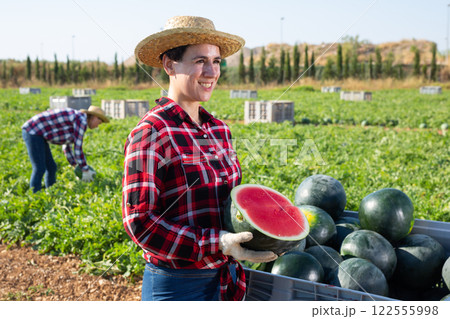 Woman with half of watermelon on fruit farm 122555998